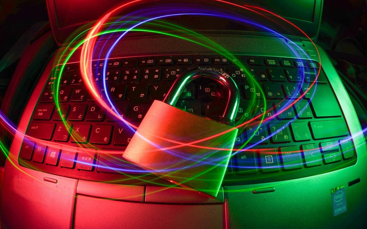 Padlock resting on a laptop under moving colored light